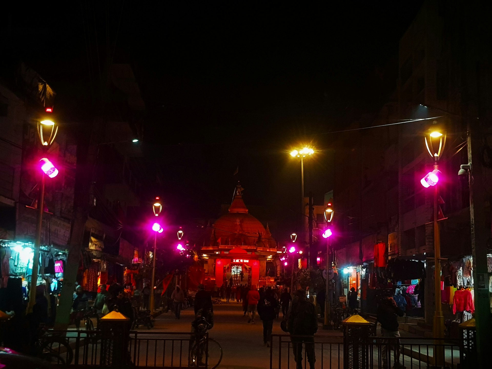 a group of people walking down a street at night